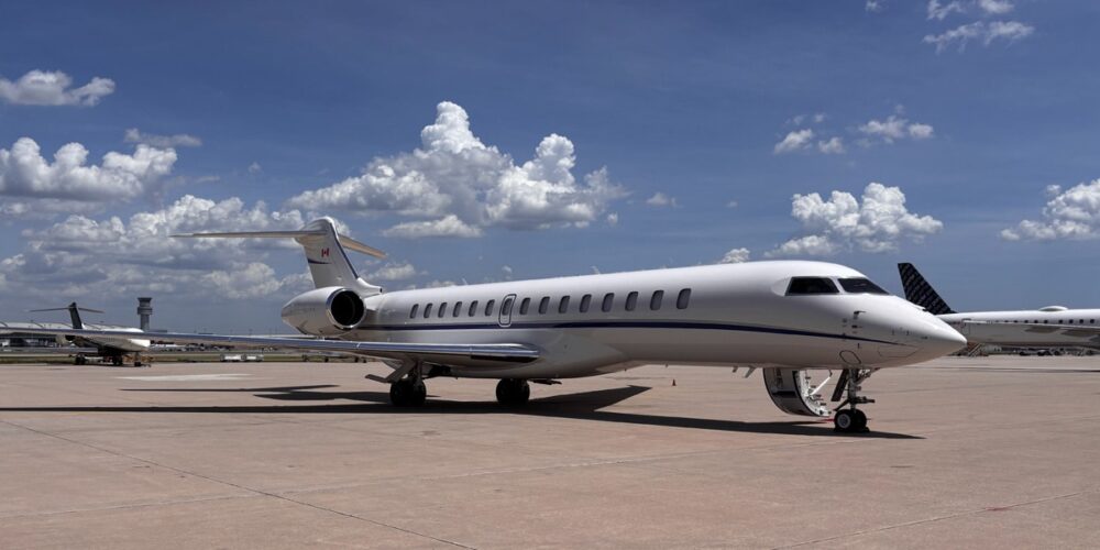 A Bombardier Global 7500 parked on the ramp at Toronto Pearson Airport under a clear sky with fluffy white clouds.
